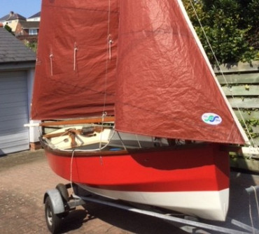 wooden sailing dinghy on a trailer