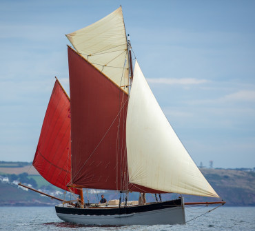 Traditional wooden gaff rigged vessel under sail